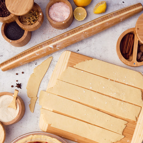 Rolling pin, salt boxes, and cutting board with a pie crust on it